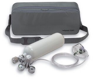 Graue Tragetasche mit Schultergurt, davor eine kleine Sauerstoffflasche mit Druckminderer, Schlauch und Maske.